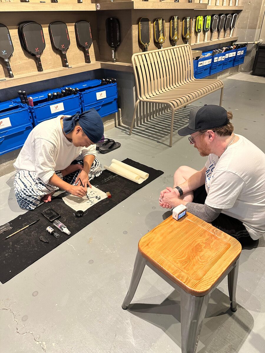 A master calligrapher at work at Pickleball One in Ginza