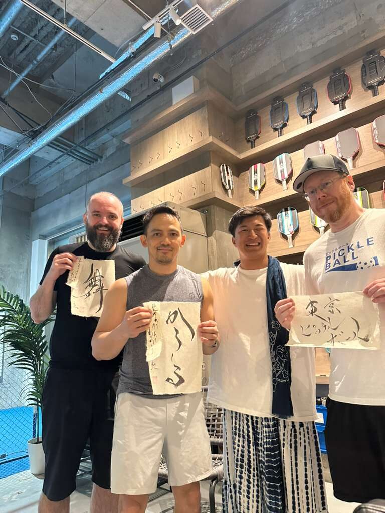 Our crew with the calligraphy pieces at Pickleball One, Ginza